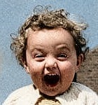 Restored by Colorify: a laughing toddler with curly hair, face unchanged